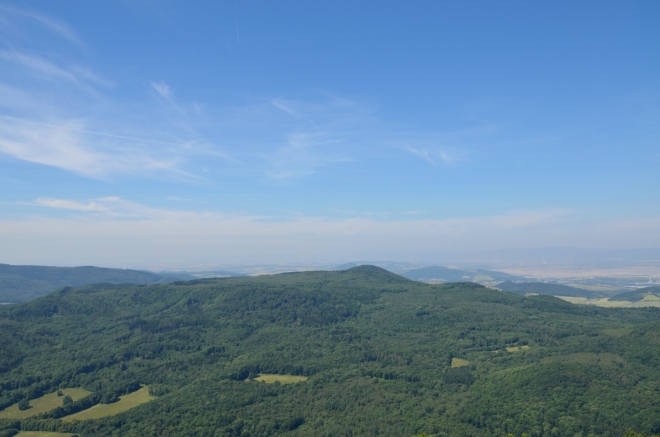 Začínáme na západní straně, zde krajině vládnou lesy. Uprostřed fotky je patrně Pařez, třetí nejvyšší vrchol Českého středohoří (736 m).