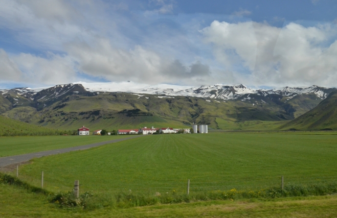 Skógar tvoří jen několik farem s krásně červenými střechami. Vzadu se tyčí Eyjafjallajökull.