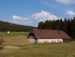 Pohled přes louky k starému domu a ke kapličce nad samotami.