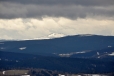 Co přitahuje zrak nejvíc je vzdálený Roklan (1 453m). Se zasněženým vrcholem kontrastuje s černými mraky a zalesněnými nižšími hřbety kolem Medvědí hory (1 223m).